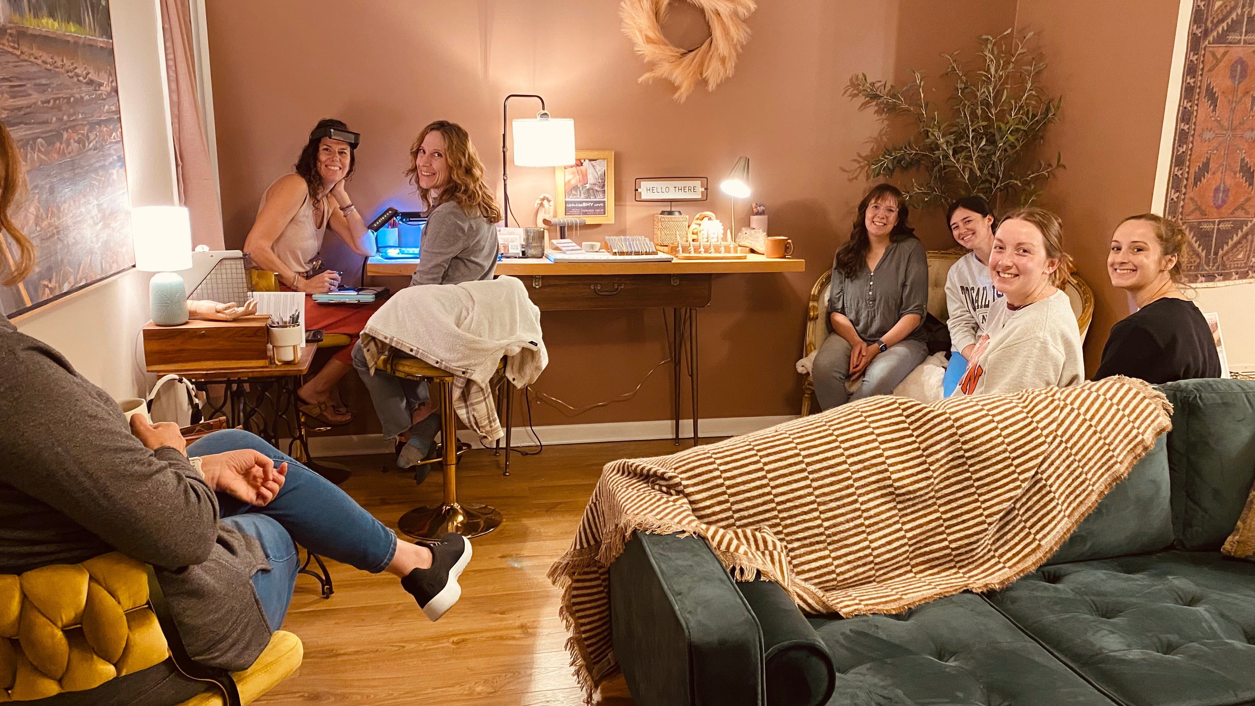 Group of people in a living room setting with a couch and coffee table.